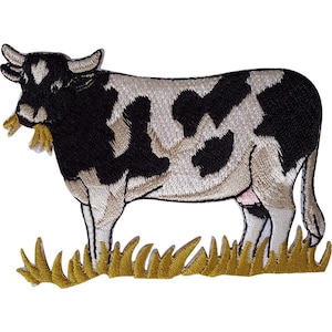 May include: An embroidered iron-on patch featuring a black and white cow standing in a patch of yellow grass. The cow is depicted in profile, facing left, with detailed stitching showing its spotted hide, horns, and a small tuft of grass in its mouth.