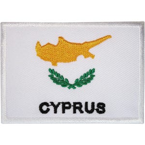 May include: A rectangular embroidered patch featuring a white background with a gold-colored map of Cyprus centered above two crossed green olive branches. The word CYPRUS is stitched in bold black capital letters along the bottom edge.