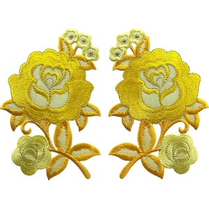 May include: Two symmetrical embroidered patches featuring large yellow roses with cream-coloured centres, smaller yellow flower buds at the top, and additional small yellow blossoms at the bottom, all connected by embroidered stems and leaves.