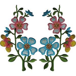 Puede incluir: Dos parches florales bordados simétricos que presentan tallos con hojas verdes y flores en tonos rosa, azul claro y amarillo. Cada parche muestra una flor rosa central en la parte superior, una flor azul debajo y capullos más pequeños.