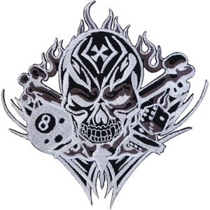 May include: An embroidered patch featuring a central skull with tribal-style black and white detailing. The skull is surrounded by flames, a black eight ball, and a pair of dice. The design is symmetrical with sharp, pointed edges and intricate stitching.