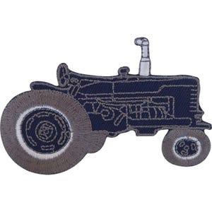 May include: A dark blue embroidered patch in the shape of a tractor. The design features a large rear wheel and a smaller front wheel in grey, with a white exhaust pipe extending upward. The tractor body is outlined with grey stitching.