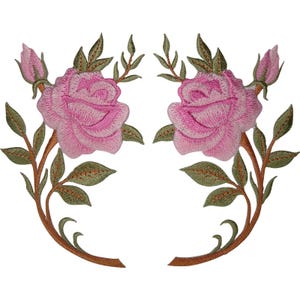 Peut inclure: Deux écussons brodés symétriques représentant des roses roses avec des feuilles et des tiges vertes. Chaque écusson présente une rose épanouie, un petit bouton de rose et des tiges incurvées avec du feuillage, réalisés en fil détaillé.