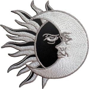 May include: A circular embroidered patch featuring a stylised sun and crescent moon design. The sun rays are white and grey, while the moon is white with a detailed facial profile. The background of the sun is solid black, creating a high-contrast celestial motif with intricate thread work throughout the entire piece.