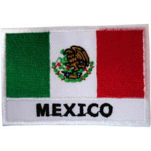 Può includere: Una toppa ricamata rettangolare che raffigura la bandiera del Messico con strisce verticali verde, bianca e rossa. La striscia bianca centrale mostra l'emblema nazionale di un'aquila su un cactus, con la parola MEXICO ricamata in nero sotto.