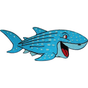 May include: An embroidered patch of a light blue whale shark with white spots and dark blue horizontal stripes. The shark has a wide, open mouth showing a red tongue, a single visible red eye, and a large tail fin, all outlined in black thread.