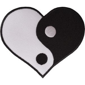 May include: A heart-shaped embroidered patch featuring a black and white yin-yang design. The left side of the heart is white with a black circular dot, while the right side is black with a white circular dot, all bordered by black stitching.
