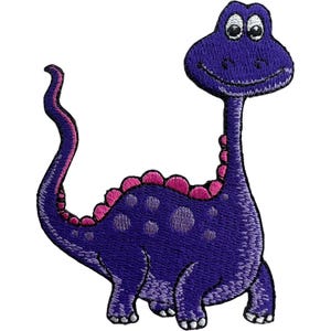 May include: An embroidered iron-on patch featuring a cartoon dinosaur with a long neck and tail. The dinosaur is deep purple with lighter purple spots, a row of bright pink spikes along its back, and large white eyes with black pupils.