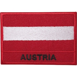 Puede incluir: Un parche rectangular bordado que presenta el diseño de la bandera de Austria con franjas horizontales rojas y blancas. La palabra AUSTRIA está bordada en letras mayúsculas negras sobre la franja roja inferior. El parche tiene un borde rojo grueso.