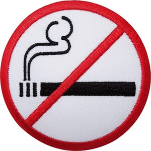 Peut inclure: Un écusson brodé circulaire avec un fond blanc, une bordure rouge et une barre diagonale rouge. Le motif présente un graphique noir brodé représentant une cigarette horizontale avec de la fumée, formant un symbole d'interdiction de fumer.