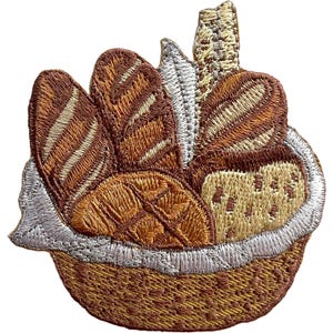 Peut inclure: Un écusson brodé représentant une collection de pains variés, incluant des baguettes et une miche à la texture visible, disposés dans un panier tressé. Le motif utilise des fils dans des tons marron, beige et crème avec des reflets blancs.