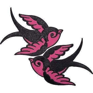 Op de afbeelding: Twee geborduurde zwaluw-patches in een opvallende kleurencombinatie van zwart en felroze. Elke vogel is afgebeeld in een vliegende houding met gespreide vleugels, waarbij gedetailleerd stikwerk de veren en het silhouet van de vogel definieert.