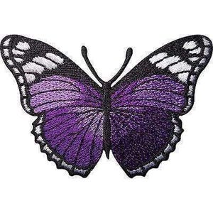 Op de afbeelding: Een geborduurde vlinderpatch met levendige paarse vleugels, zwarte randen en witte accenten. Het ontwerp bevat een zwart centraal lichaam en twee voelsprieten, met gedetailleerd stikwerk over de vleugels voor een gestructureerd uiterlijk.