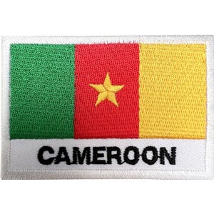 May include: A rectangular embroidered patch featuring the flag of Cameroon with vertical green, red, and yellow stripes. A yellow five-pointed star is centered in the red stripe. The word CAMEROON is stitched in black capital letters on a white base.