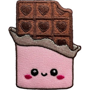Peut inclure: Un écusson brodé en forme de tablette de chocolat avec un morceau croqué sur le dessus. La partie supérieure est marron avec des empreintes en forme de cœur. La partie inférieure est un emballage rose clair avec un visage souriant.