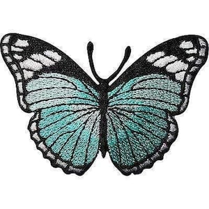 May include: An embroidered butterfly patch featuring a black body and antennae. The wings display a vibrant teal blue centre with white and black patterned borders, showcasing detailed stitching throughout the entire insect design.
