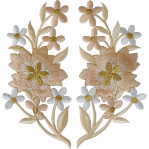 May include: Two symmetrical floral embroidered patches featuring large peach-coloured blossoms with gold centres, surrounded by smaller white and light peach flowers and leaves. The intricate stitching creates a detailed botanical design.