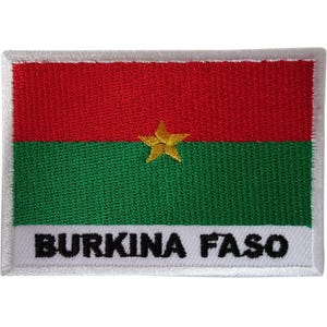 May include: A rectangular embroidered patch featuring the flag of Burkina Faso with a red horizontal top band, a green horizontal bottom band, and a central yellow five-pointed star. The white bottom border displays the text BURKINA FASO.