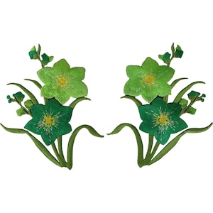 Può includere: Due toppe ricamate simmetriche con motivi floreali in tonalità verde lime e verde bosco scuro. Ogni toppa mostra due fiori aperti con centri gialli, circondati da sottili foglie verdi e piccoli steli con boccioli.