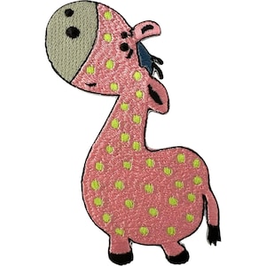 May include: An embroidered patch shaped like a cartoon giraffe with a pink body covered in lime green spots. The giraffe has a light grey face, two black eyes, a small black mouth, and black hooves at the end of its four legs and tail.