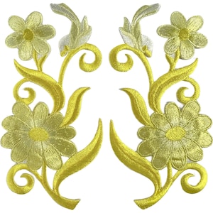 May include: Two symmetrical embroidered patches featuring yellow flowers with light green centres, accompanied by swirling stems and leaves. The design includes a larger bottom flower and a smaller top flower on each piece, rendered in bright yellow thread.