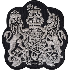 May include: A black embroidered patch featuring the Royal Coat of Arms of the United Kingdom in silver thread. The design includes a crowned lion, a unicorn, a central shield with the text DIEU ET MON DROIT on a banner at the bottom.