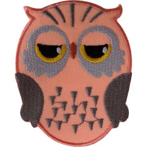May include: An embroidered owl patch featuring a peach-coloured body, dark grey wings, and grey facial discs. The owl has yellow eyes with black pupils, a small brown beak, and dark grey V-shaped markings on its chest and forehead.