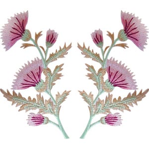 以下が含まれることがあります： ピンクとマゼンタの色合いのあざみの花、明るい緑色の茎、ギザギザした鋸歯状の葉が特徴の、左右対称の刺繍ワッペン2枚セット。花のデザインには、大きく咲いたあざみの頭花2つと、小さなつぼみ2つが含まれています。
