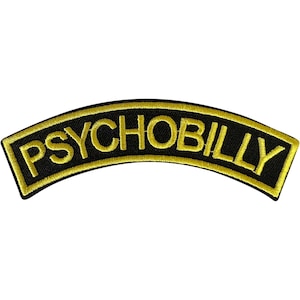 May include: A curved embroidered patch featuring the word PSYCHOBILLY in bold yellow capital letters. The text is set against a black background and is framed by a thick yellow border, creating a distinct contrast for this textile accessory.