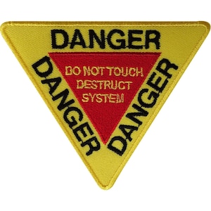 May include: A triangular embroidered patch with a yellow border and background. The word DANGER is stitched in black along the top and sides. A central red triangle contains the yellow text DO NOT TOUCH DESTRUCT SYSTEM in block letters.