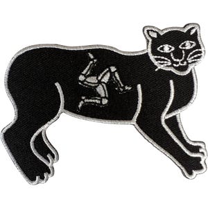 May include: A black embroidered patch in the shape of a feline, featuring a white stitched outline and a white triskelion symbol of three bent legs positioned in the centre of the body, with white thread detailing on the face and paws.