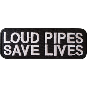 Op de afbeelding: Een rechthoekige zwarte geborduurde patch met afgeronde hoeken voorzien van de witte geborduurde tekst LOUD PIPES SAVE LIVES in twee regels. De letters zijn in een vet schreefloos lettertype en de patch heeft een dikke zwarte rand.
