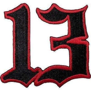 May include: An embroidered patch featuring the number 13 in a gothic-style font. The number is black with a thick, vibrant red border outlining the shape, creating a bold contrast against the white background of the patch design itself.