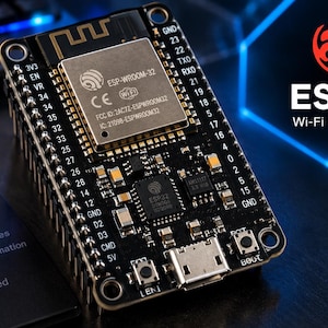 May include: A black ESP32 development board featuring a central metal shield labelled ESP-WROOM-32, Wi-Fi and Bluetooth logos, and numerous pin headers labelled with numbers. The board includes a micro-USB port, two buttons, and various surface-mounted components.