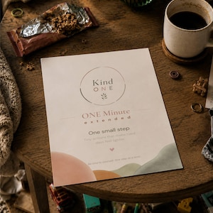 May include: A rectangular paper print featuring the text Kind ONE, ONE Minute extended, One small step, and Be kind to yourself. One step at a time. The design includes a circular frame, a small heart icon, and abstract shapes in muted peach and sage green.