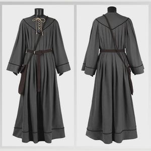 May include: A floor-length charcoal gray robe featuring long sleeves, a dark brown belt, and a small matching pouch. The neckline includes a beige lace-up closure with thin cords. Dark piping accents the seams, shoulders, and hemline.