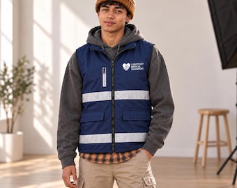 May include: A navy blue high-visibility vest with two horizontal reflective silver stripes, a zippered chest pocket, and two lower flap pockets. The chest features a white logo with a heart-shaped hand icon and the text Lightfoot Medical Transport.