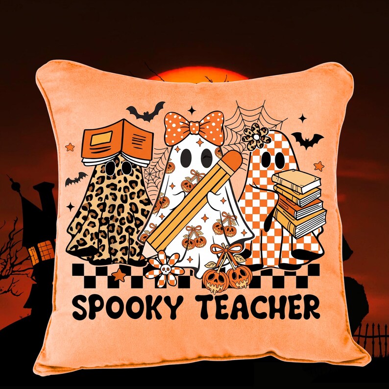May include: A square orange throw pillow featuring a graphic of three ghosts. One ghost has a leopard print, one has a bow and pencil, and one has a checkered pattern with books. The text SPOOKY TEACHER is printed in black at the bottom.