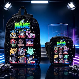 May include: A black backpack and matching lunch bag set featuring a space-themed background with colorful cartoon robot characters and the word NAME printed at the top. Each item displays various expressive robot icons with text labels.