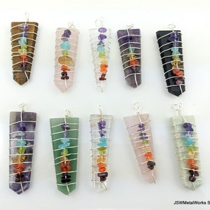 Peut inclure: Dix pendentifs chakra avec du fil d'argent enroulé autour de chacun. Les pendentifs sont faits de divers cristaux et pierres, notamment l'améthyste, le quartz rose, le quartz clair, l'œil de tigre, l'aventurine verte et l'obsidienne noire. Chaque pendentif présente sept pierres de couleurs différentes représentant les sept chakras.