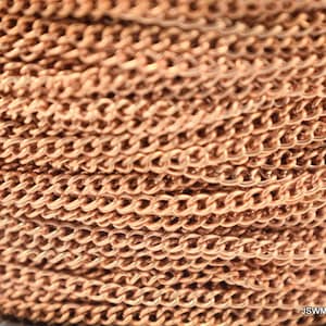 Puede incluir: Primer plano de un carrete de cadena de cobre. La cadena es de estilo curb clásico con un acabado metálico brillante.