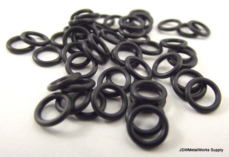May include: A pile of black rubber o-rings. The o-rings are small and round, and they are all the same size.