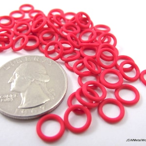 May include: A pile of bright pink rubber O-rings, approximately the size of a US quarter.