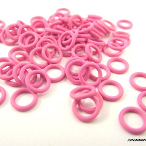 May include: A large pile of pink metal jump rings. The rings are small and round, and they are perfect for jewelry making.