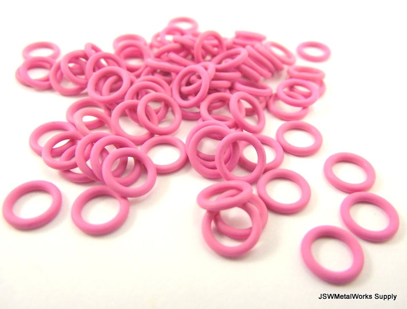 May include: A large pile of pink metal jump rings. The rings are small and round, and they are perfect for jewelry making.