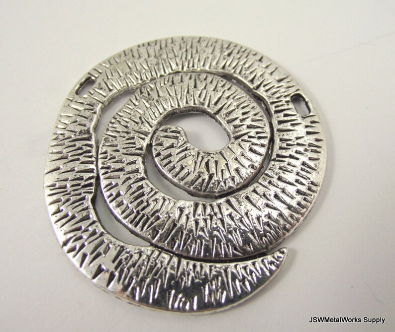 K&ouml;nnte beinhalten: Silberner Metall-Anh&auml;nger mit einem strukturierten Spiraldesign. Der Anh&auml;nger hat zwei L&ouml;cher zum Anbringen an Schmuck oder anderen Bastelarbeiten.