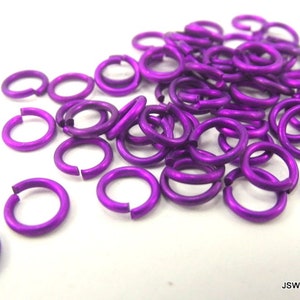 May include: A pile of purple jump rings, also known as split rings, are made of metal and are used for jewelry making.