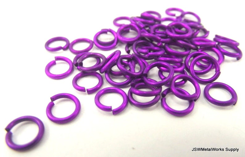 May include: A pile of purple jump rings, also known as split rings, are made of metal and are used for jewelry making.