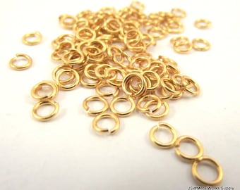 May include: A pile of gold jump rings, a type of jewelry finding used for connecting chains, cords, and other jewelry components.