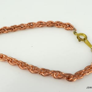 May include: A copper chain necklace with a twisted rope design and a brass clasp.